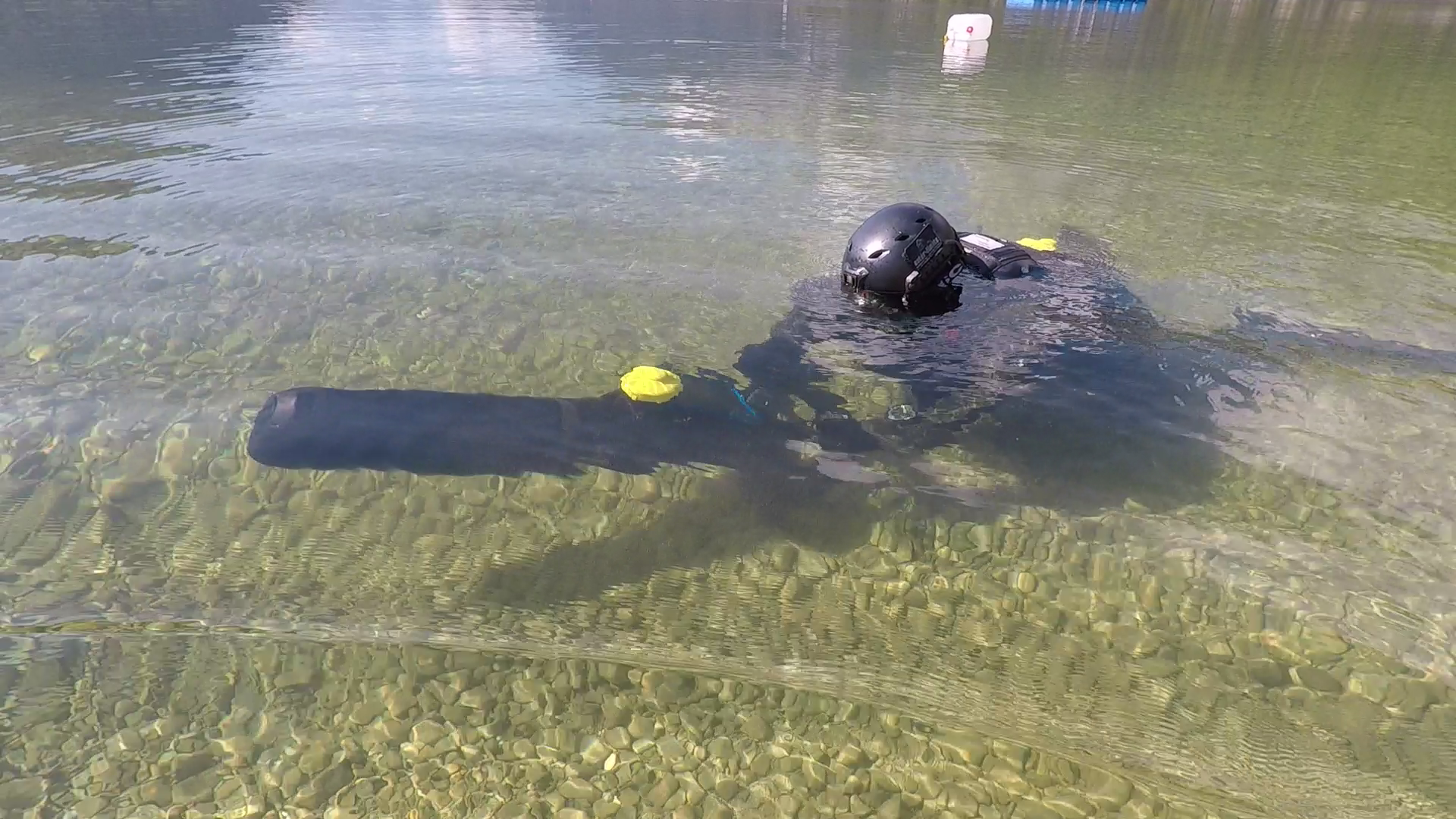 Diver using a DPV with a yellow UWIS unit in shallow water